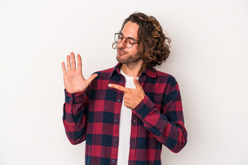 Young caucasian man isolated on white background smiling cheerful showing number five with fingers.