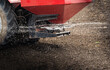 Tractor spreading artificial fertilizers in field