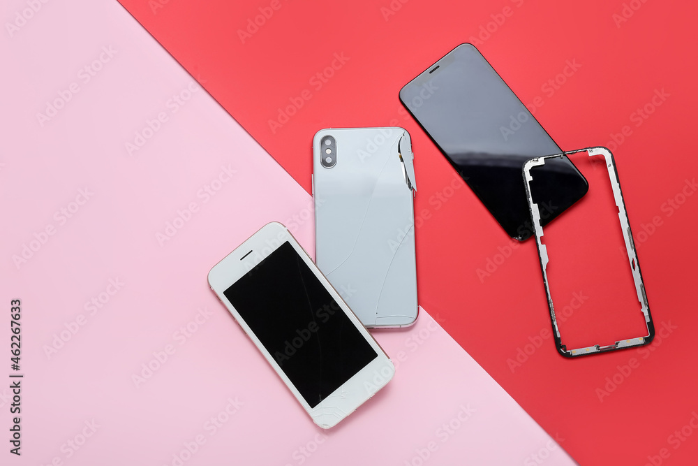 Damaged mobile phones, display glass on pink and red background