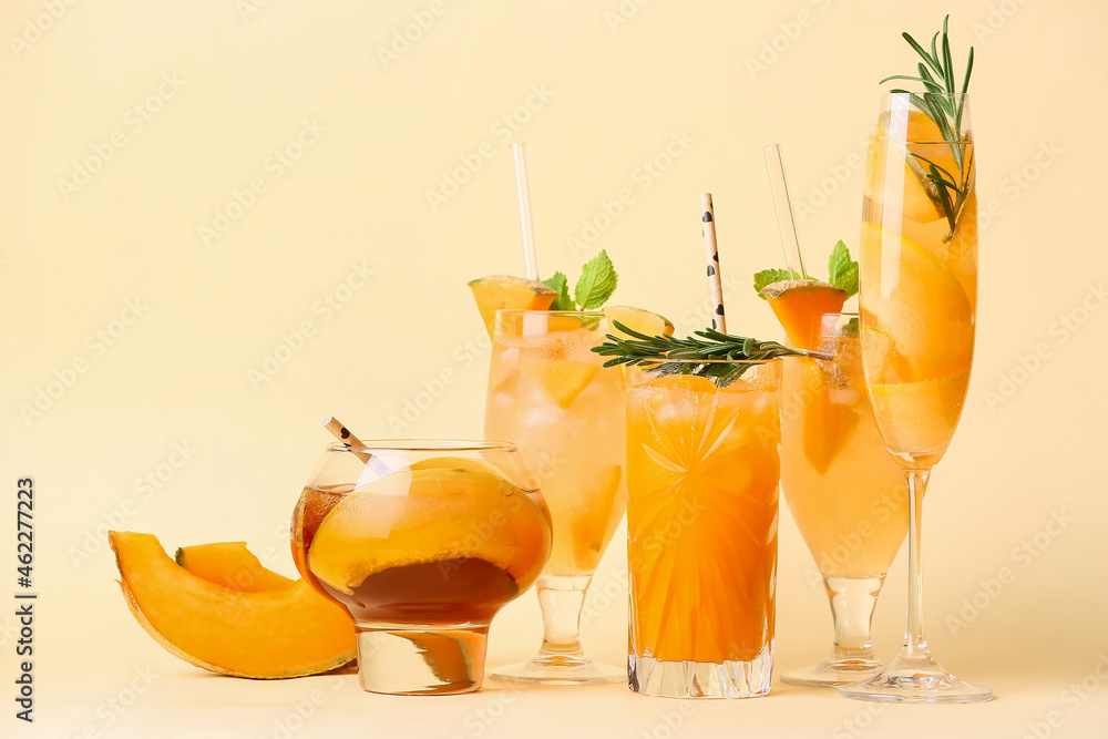 Glasses of different melon cocktails on color background