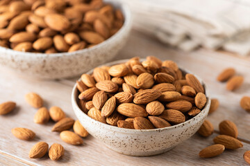 Wall Mural - Bowl of raw almonds on a wooden table