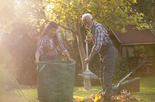 Man And Woman Working In Garden In Autumn