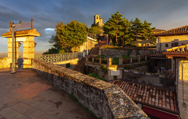 Wall Mural - San Marino. Old street and tower at sunset.