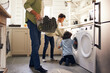 © Southworks - Boys doing laundry with father holding basket