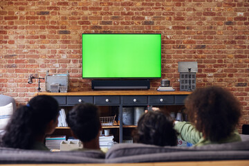 Family watching TV at home on sofa.