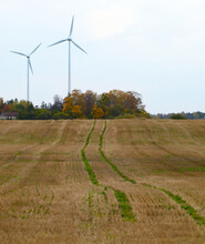 Two Wind Turbines In The Field.