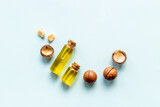 Fototapeta Desenie - Macadamia nut oil in glass bottle with nuts. Essence extra virgin oil for food or cosmetic