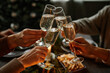 © Seventyfour - Close up of four people enjoying Christmas dinner together and toasting with champagne glasses while sitting by elegant dining table with candles