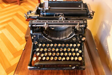 An Old Vintage Typewriter With Spanish Keyboard Over A Wooden Desk.