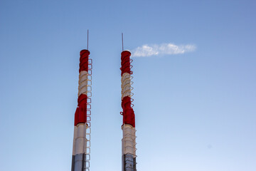 air pollution by smoke coming out of two factory chimneys. close-up from below of smoke coming out o