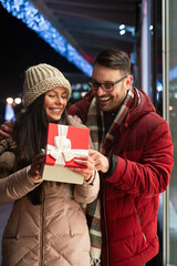 Wall Mural - Young couple in love is celebrating with gift. Christmas birthday valentines day present concept