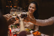 © Syda Productions - holidays, party and celebration concept - multiethnic group of happy friends having christmas dinner at home and drinking wine