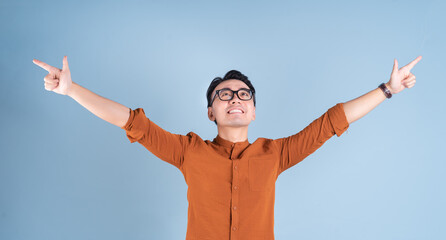 Sticker - Young Asian businessman posing on blue background