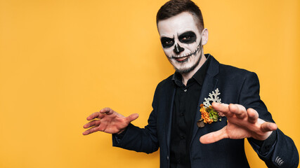 Wall Mural - Studio shot of a man on a bright background in a costume of evil spirits at a Halloween costume party. Celebrating Halloween