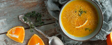 Bowl Of Moroccan Carrot And Orange Soup On A Wooden Table