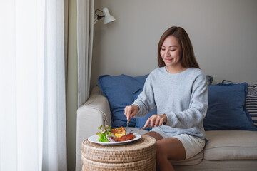 A young woman eating American breakfast at home