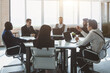© xartproduction - Group of young business people working and communicating while sitting at the office desk together with colleagues sitting. business meeting