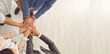 © Studio Romantic - Young business people put hands together, top view from above. Male and female team members united by feeling of solidarity. White blank copyspace banner background. Teamwork and partnership concept