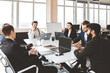© xartproduction - Group of young business people working and communicating while sitting at the office desk together with colleagues sitting. business meeting