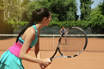 Wall Mural - Couple playing tennis on court during sunny day