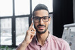 © LIGHTFIELD STUDIOS - Young arabian businessman in eyeglasses smiling while talking on mobile phone