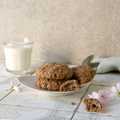 Wall Mural - a saucer with homemade oatmeal cookies and a glass of milk on a light table