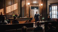 Court Of Justice And Law Trial: Male Public Defender Presenting Case, Making Passionate Speech To Judge, Jury. African American Attorney Lawyer Protecting Client's Innocents With Supporting Argument.
