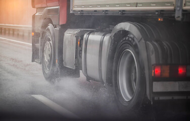 Truck chassis and wheels on a wet road in rainy weather, close-up. Safety concept and tire grip on wet roads, braking distances under emergency braking