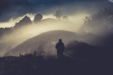 man walking in a foggy autumn landscape