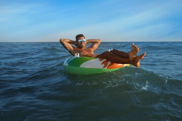 Sticker - Man with inflatable ring resting in sea