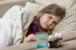 © Julie Boro - a sick girl lies in bed, in the foreground a jar of medicine
