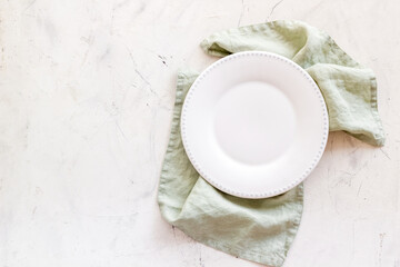 Wall Mural - Empty plate on napkin - table setting for dinner. Overhead view