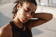 © Drobot Dean - Black sportswoman rubbing her neck while working out on parking