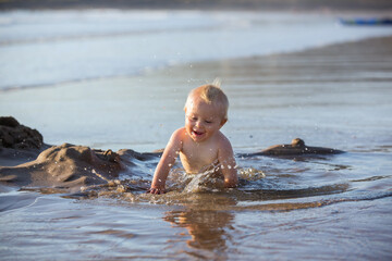 Sticker - Baby boy, playing on the beach in the water, smiling