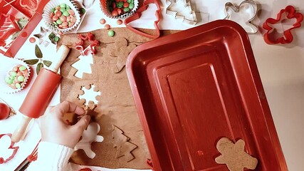 Wall Mural - Christmas, New Year cooking background. Baking ingredients and utensils - gingerbread dough, cookie cutters, rolling pin. Woman hands making festive Xmas sweet cookies bright festive red white concept