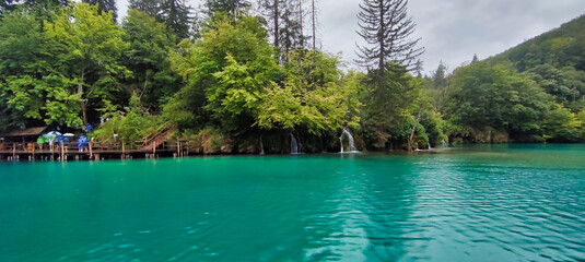 Wall Mural - View of the waterfall in Plitvice Lakes National Park. Trees and green water in lake. Green hills. Croatia. Europe	