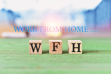 Three wooden cubes with letters WFH on wood floor cubes with letters word WFH (WORK FROM HOME) the effect of COVID 19 concept