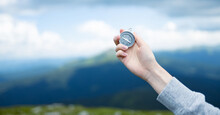 Traveler Hand Holds Compass Against Beautiful Carpathian Mountains View. Horizontal Banner With Place For Text.
