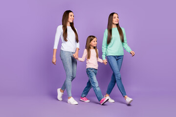 Sticker - Photo of adorable pretty daughters mom dressed sweaters walking holding hands looking empty space isolated purple color background