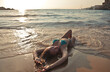 © Cavan Images - young woman lying on the beach