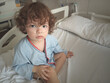 © Jabell - Niño de 2 años sentado en una cama de hospital, enfermo de bronquiolitis causada por bocavirus, con aporte de oxígeno mediante gafas nasales o cánula nasal.