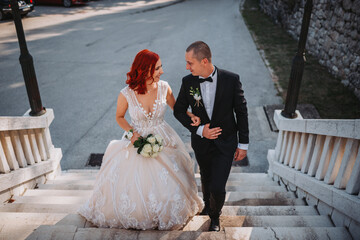 Wall Mural - Closeup shot of a groom and a bride with red hair looking at each other, posing for the camera