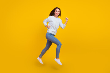 Wall Mural - Full size photo of cheerful happy young woman jump up run sale good mood isolated on yellow color background