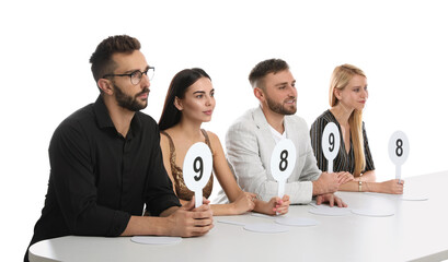 Wall Mural - Panel of judges holding different score signs at table on white background