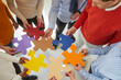 © Studio Romantic - Team of creative people and business colleagues meeting in office and joining colorful jigsaw puzzle pieces. Close up. Concept of teamwork and looking for solutions together