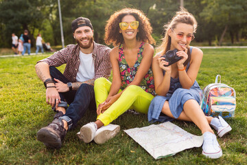 Wall Mural - happy young company of friends sitting park