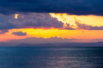 Wall Mural - Stunning dramatic, cloudy sunrise over a calm water. Natural background, Sardinia, Italy.
