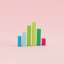 A Creative Arrangement Of Statistical Data Representation Made Of Wooden Cuboids On A Pink Background. Minimal Data Or Development Concept. Statistics, Analysis And Diagram Inspiration.