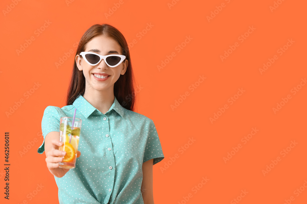 Beautiful young woman with fresh lemonade on color background