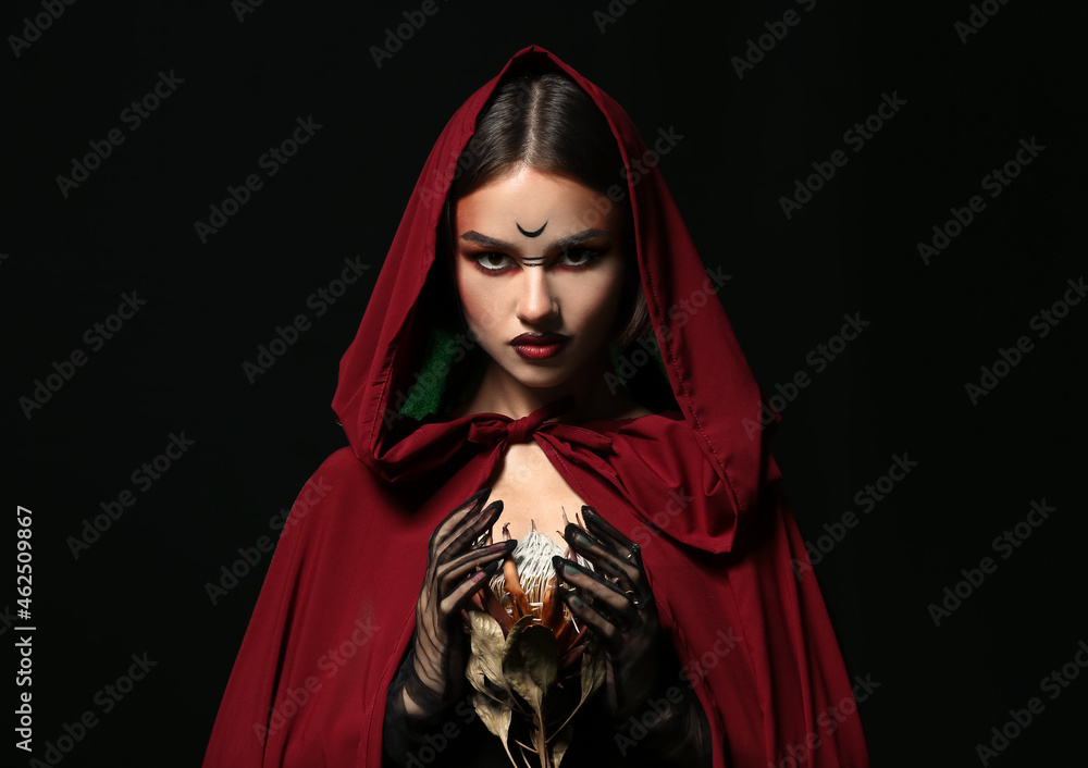 Beautiful woman dressed as witch for Halloween on dark background